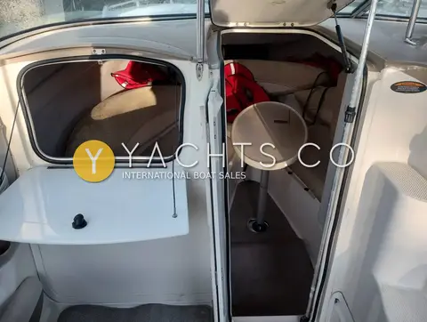 Maxum 2300 SC: open cabin door showing the cuddy interior with toilet and forward seating
