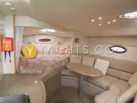 Maxum 3000 SCR: saloon with curved seating, oval table and offset forward berth beyond a curtain