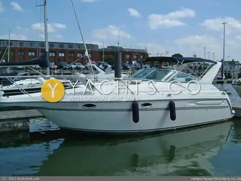 Maxum 3000 SCR: port side afloat in a marina with canopy up and fenders out