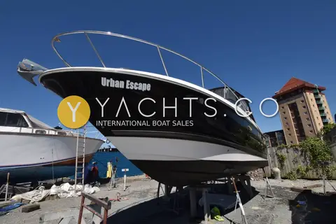 Monterey 245 Sport Cruiser: glossy dark blue hull and white boot stripe from the port bow, ashore