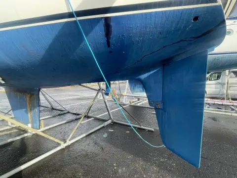 Moody 31: close view of blue antifouled hull and one bilge keel, boat standing on a cradle