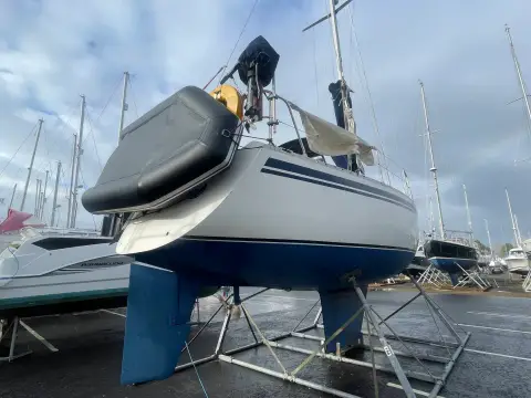 Moody 31: stern view ashore showing outboard bracket, spray hood and bilge keels on blue antifouled hull