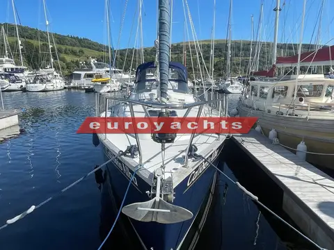 Moody 38 CC Caledonia: bow view from the pontoon showing anchor, pulpit and blue hull in the marina