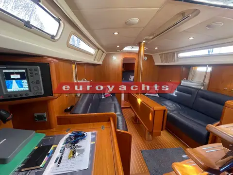 Moody 38 CC Caledonia: saloon with dark blue leather seating, cherry joinery and chart table with plotter