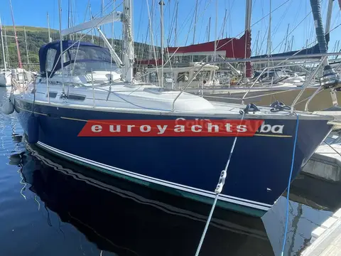Moody 38 CC Caledonia: port side of dark blue hull with white boot stripe and name, alongside the pontoon