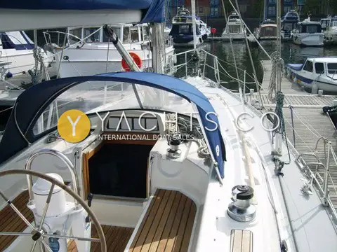 Moody 38CC Yacht For Sale: cockpit looking forward under blue spray hood, with wheel, winches and teak sole
