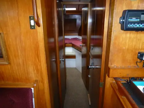 Moody 42 CC Ketch: wooden passageway looking forward towards the V-berth cabin, instrument panel on the right