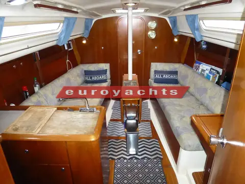 Moody S31: saloon looking forward from the galley, twin settees and central table in warm wood
