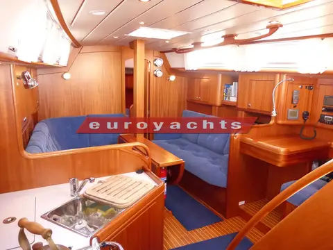 Najad 380: mahogany saloon with blue upholstered settees, galley sink in the foreground