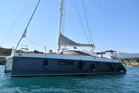 Nautitech 542: side view on a sunny day with the hills of the coastline behind