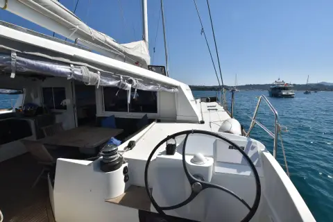 Nautitech 542: starboard helm station with wheel and winch, looking out over the anchorage