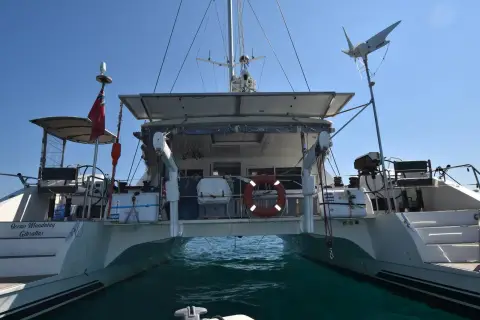 Nautitech 542: stern view between the hulls showing the aft deck, bimini and wind generator