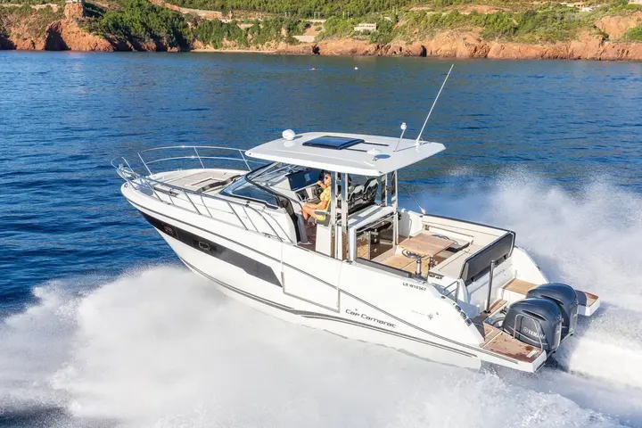 Jeanneau Cap Camarat 10.5 WA Serie 2: boat underway from above, showing hardtop with skylight, aft cockpit table and twin outboard engines