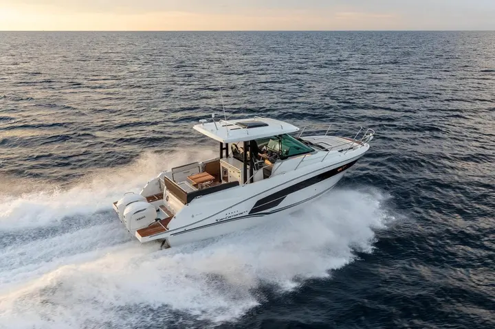 Jeanneau Cap Camarat 10.5 WA Serie 2: underway at sea, aerial view of cockpit table, hardtop and twin outboard engines leaving a wake