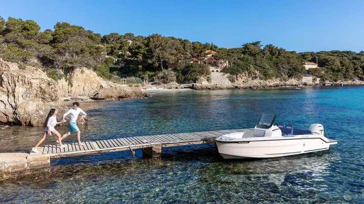 Jeanneau Cap Camarat 6.0 CC: white hull tied alongside a jetty in turquoise water, with console, windscreen and stern outboard visible