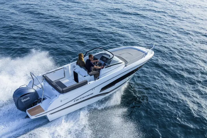 Jeanneau Cap Camarat 7.5 WA: aerial view at speed showing cockpit seating, helm station, windscreen and Yamaha outboard engine