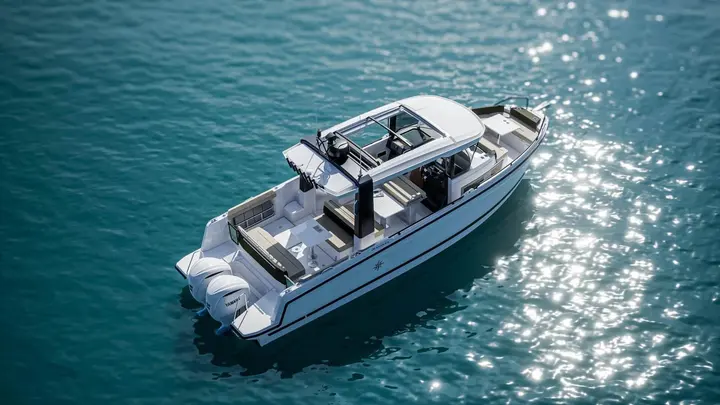 Jeanneau EX 34 Hardtop: aerial view of the boat on open water showing cockpit, hardtop, bow seating and twin outboards