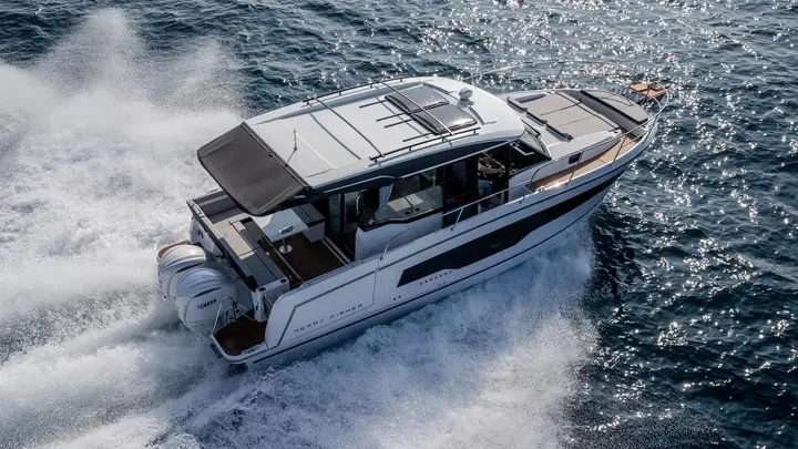 Jeanneau Merry Fisher 1095 Coupe SERIE2: aerial view from astern of the boat under way, showing cockpit, twin outboards and roof sunroof
