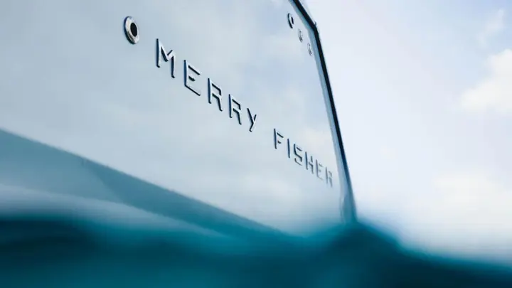 Jeanneau Merry Fisher 1095 Fly SERIE2: close-up of Merry Fisher lettering on the white hull side, seen from water level