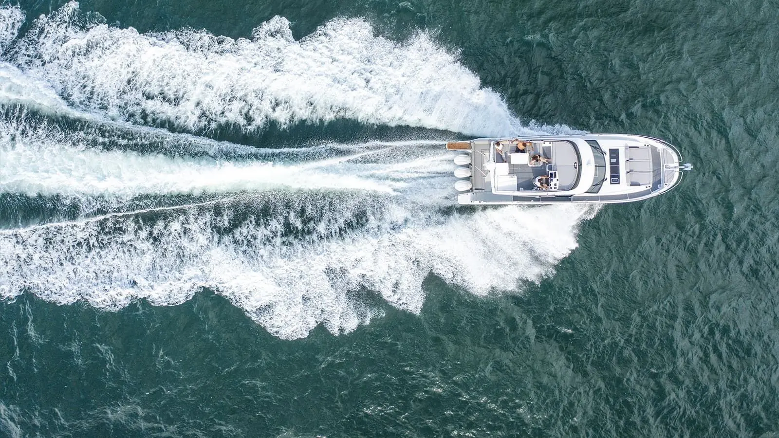 Jeanneau Merry Fisher 1295 Fly: aerial view from above of the motor boat under way, triple outboards leaving a wide white wake