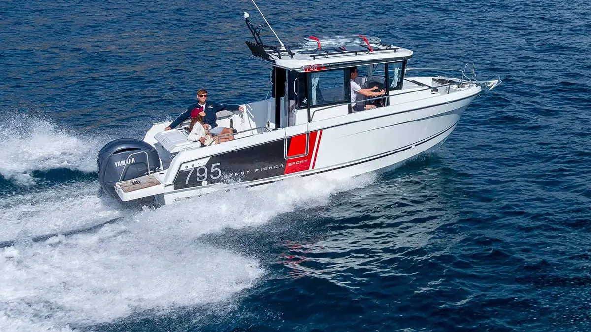 Jeanneau Merry Fisher 795 Sport: white hull with 795 graphics underway at speed, two people seated in the cockpit, skipper at the helm