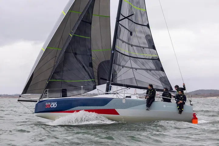 Jeanneau Sun Fast 30 OD: under sail upwind with dark sails, crew of four sitting on the windward rail