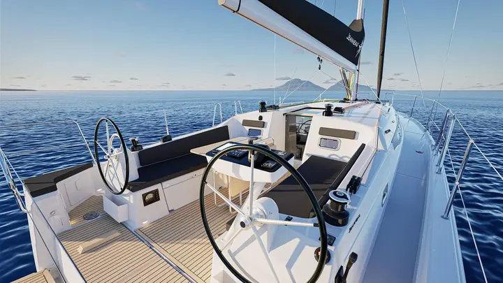 Jeanneau Sun Odyssey 385: cockpit with twin black helm wheels, central table, dark cushions and teak-style flooring