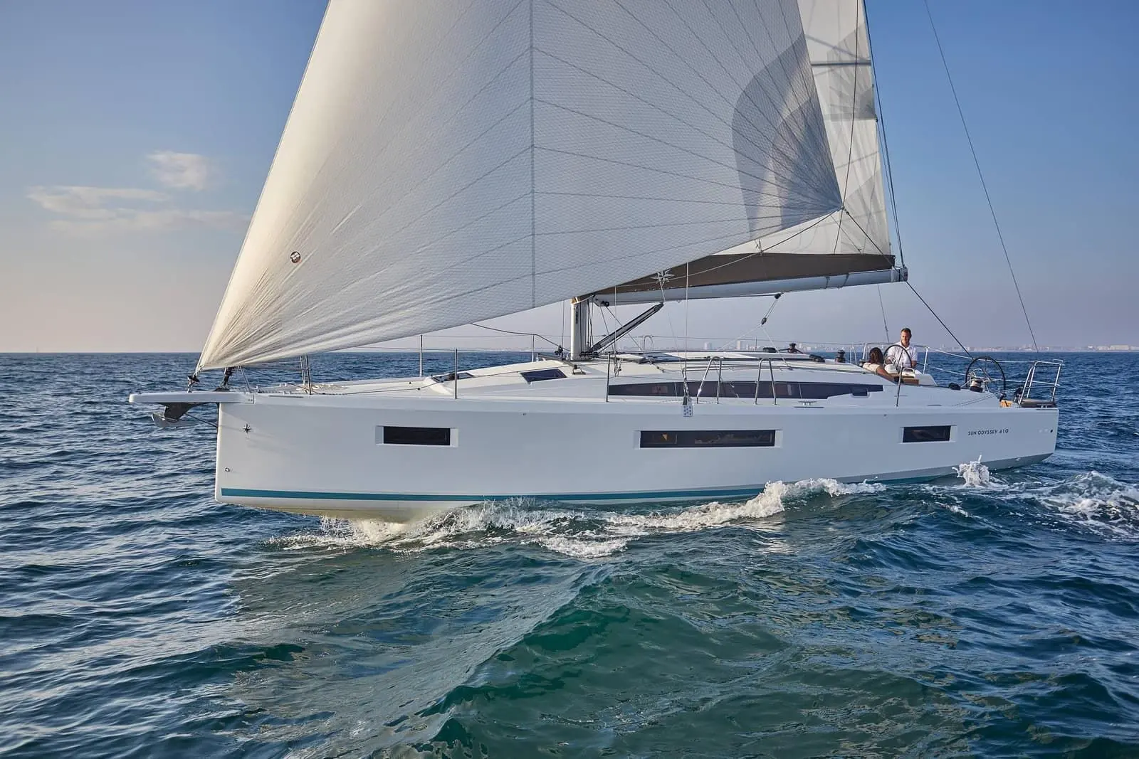Jeanneau Sun Odyssey 410: side view under sail with large headsail set, white hull with long hull windows