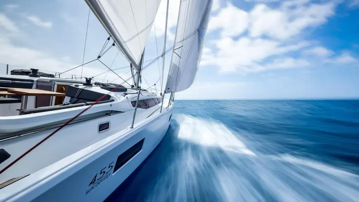 Jeanneau Sun Odyssey 455: low view along the starboard side deck under sail, bow wave rushing past the hull
