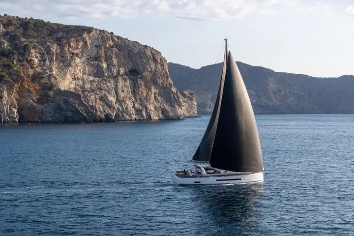 Jeanneau Yachts 55: close side view under sail showing white hull, dark sails and people in the cockpit