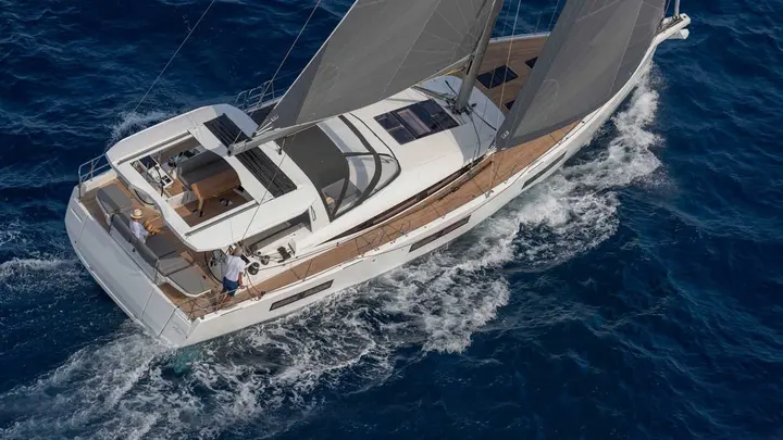 Jeanneau Yachts 60: aerial view under sail showing teak side decks, cockpit seating and twin helms aft