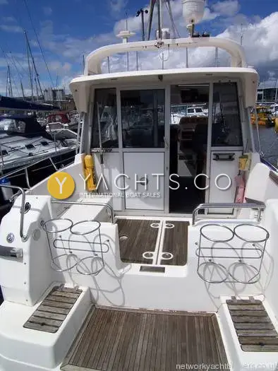 Nimbus 310 Coupe: stern view showing teak bathing platform, transom steps and cockpit with fender racks
