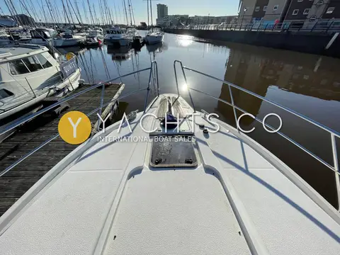 Nimbus 380 Commander: foredeck and bow rails looking forward across a calm marina at low sun