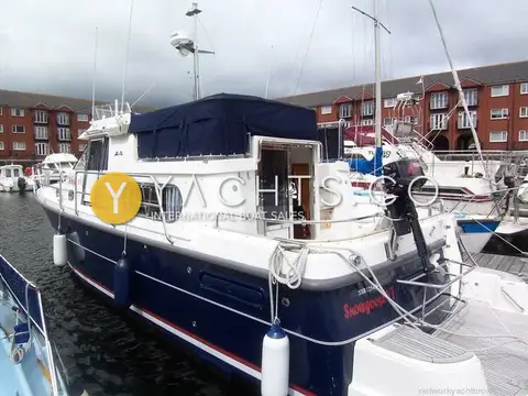Nimbus 380 Commander: starboard quarter view of blue hull at Swansea Marina with outboard on stern rail