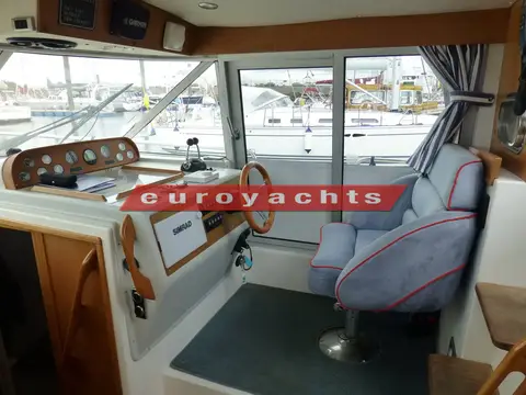 Nimbus 380 Commander: wheelhouse with wooden wheel, instrument panel and blue upholstered helm seat