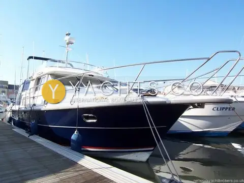 Nimbus 380 Commander Reduced: port bow view of the blue hull and radar mast, alongside a marina pontoon