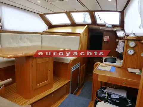 Nordship 380 DS: raised saloon seating and dining table opposite the chart table, looking aft