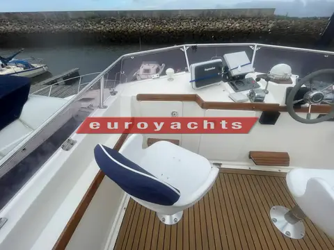 Northshore Yachts Sabreline 395 Trawler: flybridge helm with white pilot seat, teak sole and repeat navigation instruments