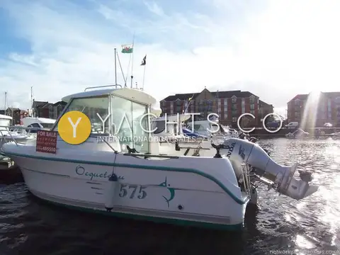 Ocqueteau 575: port side view of the hull with teal stripe and model name, moored in Swansea marina