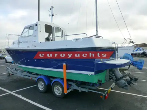Orkney Boats Pilothouse 24: starboard side on the trailer showing wheelhouse, roof mast and outdrive at the stern