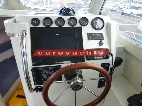 Orkney Boats Pilothouse 24: helm console with engine gauges, touchscreen plotter, VHF radio and wooden-rimmed wheel