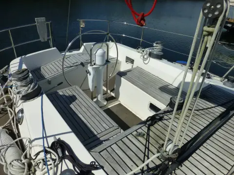 Oyster 435: cockpit with wheel and binnacle compass, grey sole panels and winches on the coamings