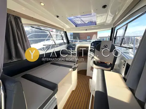 Parker 750 CC: wheelhouse looking forward with grey upholstered seating, helm seat and opening roof hatch