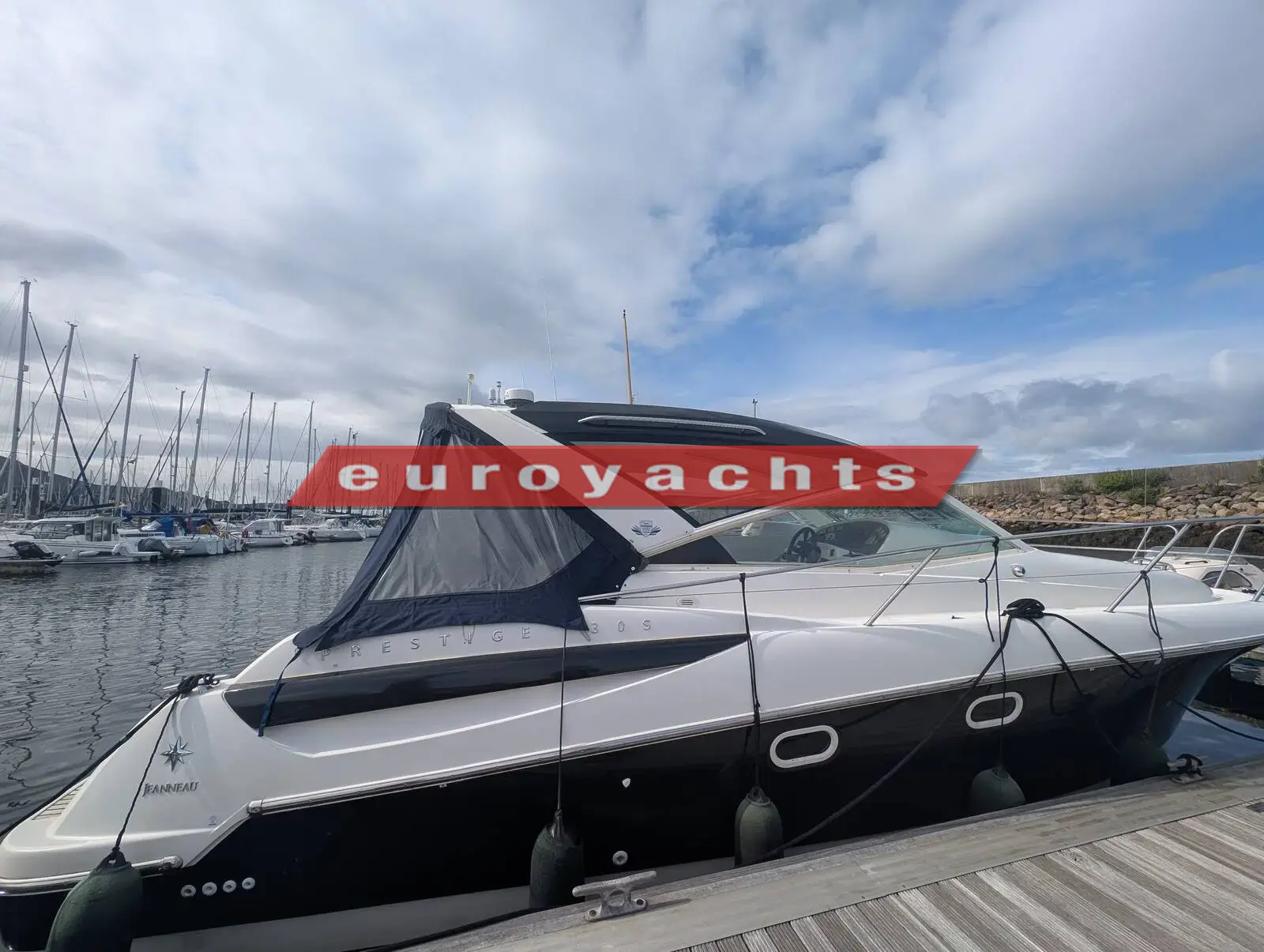 Prestige 30S: starboard side moored at a pontoon, dark hull band and canvas cockpit cover fitted