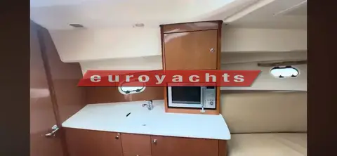 Prestige 30S: galley with light worktop, microwave in a wood cabinet and two portholes