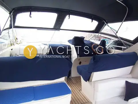 Princess 366: cockpit under full camper cover with blue seat covers, wooden wheel and teak floor