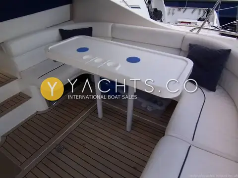 Princess 366: cockpit dining area with white U-shaped seating, white table and teak laid floor