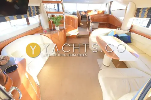 Princess 65: saloon looking forward past cream sofas and table to the steps up to the helm