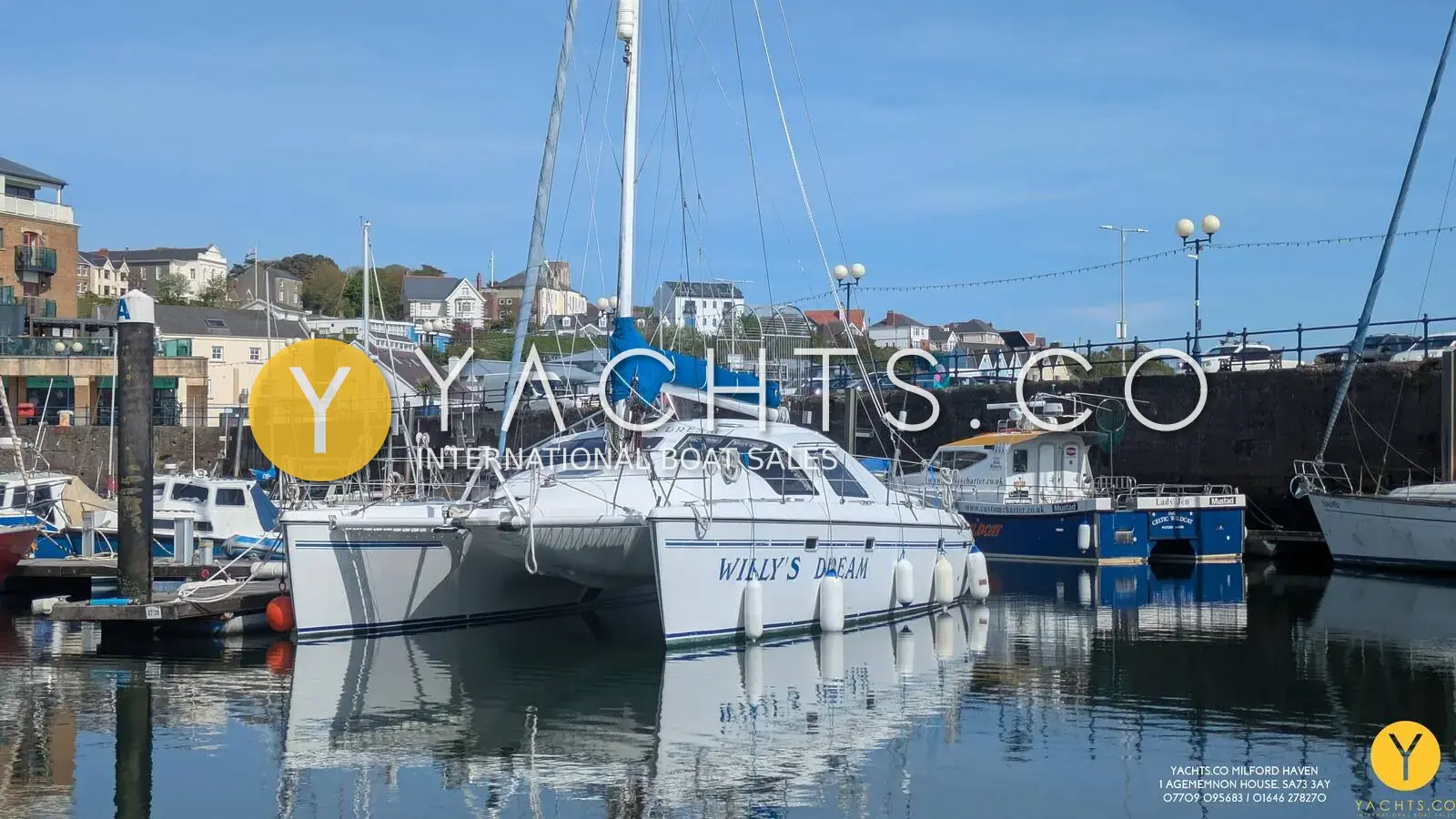 Privilege 37 Catamaran: white catamaran afloat in a harbour with houses on the hillside behind