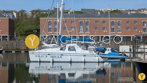 Privilege 37 Catamaran: catamaran with name on hull moored in a marina beside brick buildings